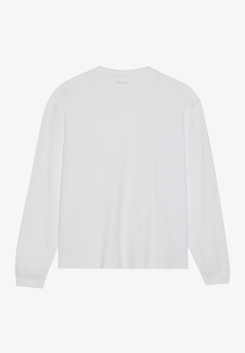 Camiseta blanca de manga larga hecha de suave algodón. Cuello redondo y corte recto con mangas largas y detalles de costura sutiles. Textura suave.