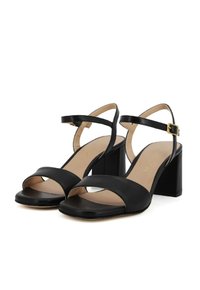 Sandali con tacco in pelle nera, con due ampie cinghie, design con punta aperta, cinturino alla caviglia con fibbia dorata e tacco spesso.