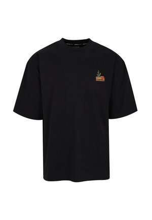 Schwarzes, übergroßes T-Shirt mit kurzen Ärmeln, Rundhalsausschnitt und kleinem, buntem Kaktuslogo auf der linken Brustseite.
