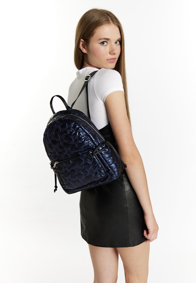 Zaino navy trapuntato realizzato in materiale lucido, con doppia cerniera, spallacci regolabili e cuciture decorative per texture.