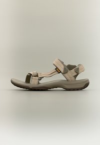 Μπεζ σανδάλι Teva με ρυθμιζόμενους ιμάντες και μαλακή σόλα, σχεδιασμένο για εξωτερική και καθημερινή χρήση.