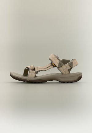Béžová sandála Teva s nastavitelnými pásky a polstrovanou podrážkou, navržená pro venkovní a běžné nošení.