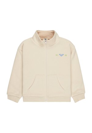 Veste en polaire couleur crème avec fermeture éclair complète à l'avant, deux poches avant, poignets côtelés, et petit logo vert "Est. 90" avec logo bleu sur la poitrine.