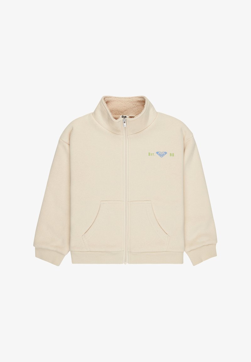 Veste en polaire couleur crème avec fermeture éclair complète à l'avant, deux poches avant, poignets côtelés, et petit logo vert "Est. 90" avec logo bleu sur la poitrine.