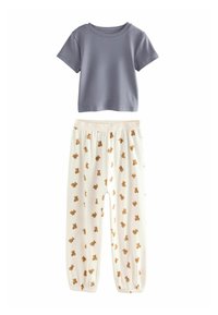 Set of pajamas featuring a short-sleeve gray top and cream pants adorned with a repeating brown teddy bear pattern. Soft fabric and elastic waistband.