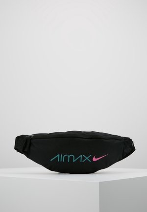 Sac banane noir avec le texte « Air Max » en turquoise et le logo Nike swoosh rose sur le devant, présenté sur un piédestal blanc contre un fond uni.
