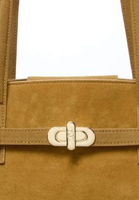 Suede handbag in mustard yellow with a smooth texture. Features a gold metal clasp and a flat strap with visible stitching details.