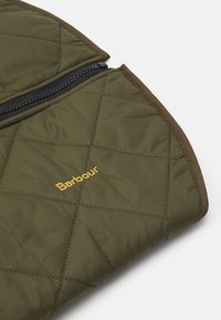 Jaqueta acolchoada verde-oliva com acabamento castanho, com um fecho zípper preto. Logótipo "Barbour" bordado em dourado na frente.