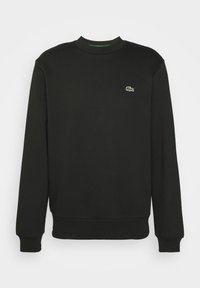 Sweat-shirt noir à manches longues avec col ras du cou, poignets et bas côtelés, avec un petit logo crocodile vert sur la poitrine gauche.