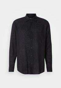Chemise noire à manches longues avec boutons, rayures verticales subtiles et poche poitrine, présentée sur un fond clair uni.