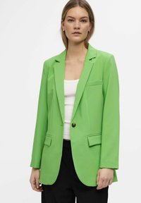 Groene blazer met een getailleerde pasvorm, enkelknopen, voorzakken en notch lapeletjes, gemaakt van gladde stof.
