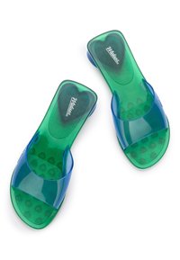 Przezroczyste zielone i niebieskie klapki na płaskiej podeszwie, z szerokim paskiem, teksturowaną wkładką wewnętrzną z wzorem serc oraz zaokrąglonymi krawędziami.