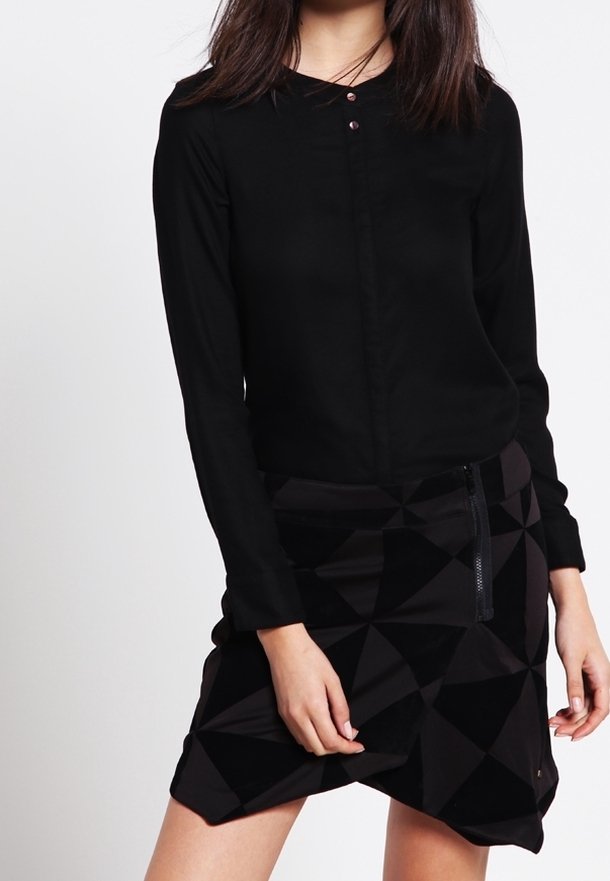 Black long-sleeve blouse with round neckline and two buttons, paired with a geometric-patterned black skirt featuring a side zipper.