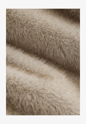 Gestructureerde imitatiebont in zachte beige tinten, met fijne draadjes en een weelderig uiterlijk, wat een warme en gezellige oppervlakte creëert.