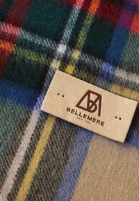 Coperta in lana a scacchi con motivi verdi scuri, rossi, blu e gialli. Include un'etichetta beige con la scritta "BELLEMERE NEW YORK" impressa in marrone.