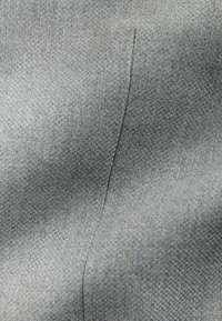 Tela gris texturizada con un fino patrón tejido. Presenta un brillo sutil y una costura visible. El material parece suave y duradero.