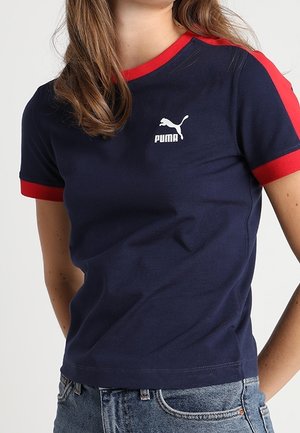 Granatowy bawełniany T-shirt z czerwonymi akcentami na rękawach i kołnierzu. Na piersi znajduje się biały logo Puma. Dopasowany krój.