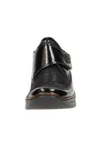 Scarpa in pelle verniciata nera con punta arrotondata, cinturino in Velcro e suola in gomma bassa. Texture liscia con dettagli di cucitura minimi.