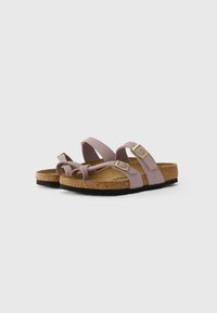 Purple strap sandals with two adjustable buckles, cork footbed, and black rubber sole. Simple, modern design with minimalist features.