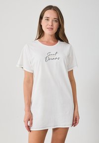 Fehér pamut pólódressz rövid ujjakkal, fekete és arany színű írásos "Édes Álmok" felirattal. Simogató textúra és laza fazon.