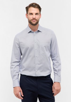 Lichtblauwe overhemdd met een geometrisch patroon, met een button-down kraag en lange mouwen, gecombineerd met donkere broeken. Gladde stoftextuur.