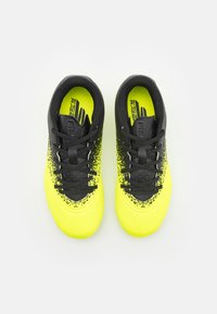 Zapatillas deportivas con cordones de color negro y un diseño en degradado amarillo brillante. Presentan una textura suave y una plantilla acolchada.