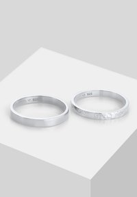 Zwei Silberringe aus 925er Sterlingsilber. Der linke ist glatt und poliert, während der rechte eine strukturierte, matte Oberfläche hat.