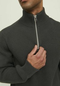 Dunkelgrauer gerippter Pullover mit hohem Kragen und silbernem Reißverschlussdetail. Hat ein enganliegendes Design und strukturiertes Gewebe.
