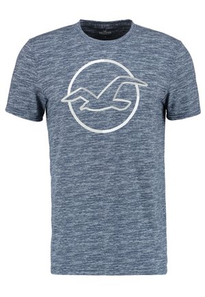 Niebieski melanżowy t-shirt z krótkim rękawem z białym obrysem lecącego ptaka w okręgu na klatce piersiowej.
