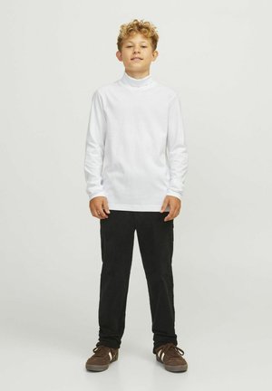 Weißes Langarm-Turtleneck-Shirt, kombiniert mit schwarzen Kordhosen und braunen Sneakers; ein klassisches und einfaches Outfit-Design.