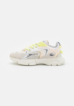 Lacoste sneakers with a mix of beige suede and mesh, featuring a yellow lace, white accents, and a grey heel tab; textured sole.