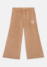 Pantalons en velours côtelé à jambes larges de couleur marron clair avec une surface texturée, dotés d'une taille avec cordon de serrage ajustable et de poches latérales. Détail du logo à l'avant.