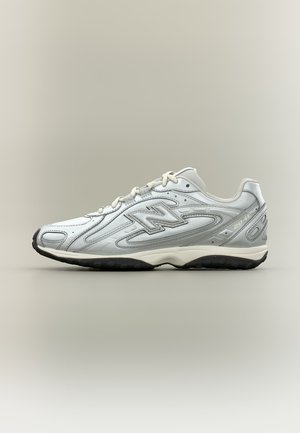 Baskets New Balance 2040 blanches et grises avec un système de laçage et une semelle en caoutchouc noir, présentées de profil sur un fond neutre.