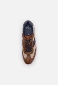 Sneaker da uomo con punta e tallone in pelle marrone, pannelli in mesh beige, dettagli blu navy e lacci neri. L'etichetta interna mostra la misura 42.