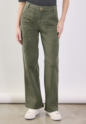 Grønne cargo bukser med høj talje, flere lommer og lige ben design. Lavet af et blødt, holdbart stof. Hvide sneakers er vist.