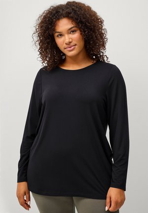 Camisa negra de manga larga hecha de tela suave con cuello redondo. Se ajusta de manera holgada, con una textura suave y un diseño minimalista.
