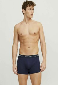 Tengerészkék boxeralsó puha derékkal, melyen az "Originals Studio" felirat található, testhezálló fazon, sima szövet textúra, combközép hosszúságú.