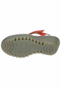 Oranje sandaal met een verstelbare strap en een lichtgekleurde rubberen zool met een gestructureerd profiel en een uitgesproken profielpatroon en merkl logo.