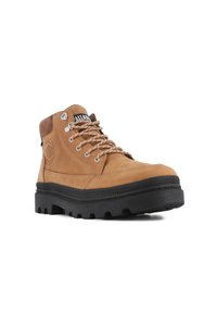Bota de senderismo de cuero marrón con un collar acolchado, logotipo circular, ojales de metal y suela de goma negra gruesa con un patrón de tacos.