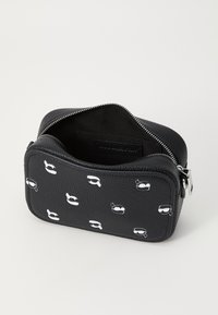 Black textured cosmetic bag with white masked character print, zip closure, and fabric-lined interior, featuring a rectangular shape.