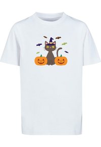 Hvid t-shirt med en grå kat med gule øjne og en lilla heksehue, flankeret af orange græskar og omgivet af små flagermus.