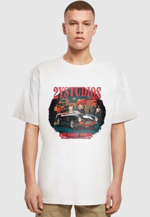 White cotton t-shirt featuring a graphic print with a vintage car, people, and text "2YSTUDIOS GRAND PRIX WORLD CHAMPIONSHIP." Short sleeves.