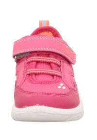 Růžové tenisky s texturovaným svrškem, suchým zipem a elastickými tkaničkami. Mají bílou podrážku a logo na boku.