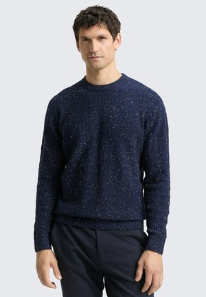Pull en maille texturée bleu marine avec un col rond, agrémenté de touches colorées partout. Les manches longues et l'ourlet côtelé finalisent le design.