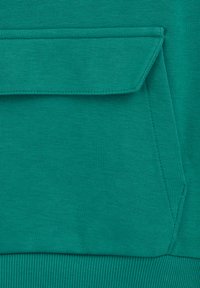 Sweat-shirt teal en tissu avec une texture côtelée et une grande poche avant dotée d'une surpiqûre. L'ourlet inférieur côtelé ajoute une touche de détail.