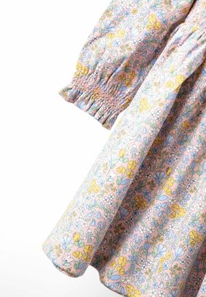 Cvjetna haljina s ružičastom pozadinom, koja sadrži plave i žute uzorke cvijeća, elastične balonske rukave i nabranu teksturu uz šavove.