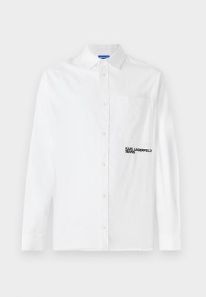 Camisa branca de manga longa, com botões, feita de algodão, apresentando um bolso no peito e um logótipo bordado a preto "KARL LAGERFELD JEANS" na frente.