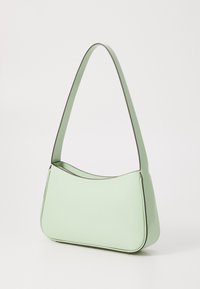 Sac à main vert menthe avec une silhouette courbée, texture lisse et garniture contrastante. Il dispose d'une seule bandoulière pour le porter.