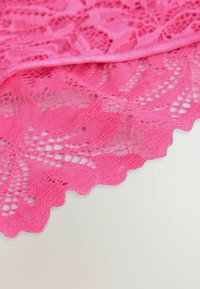 Tessuto in pizzo rosa brillante con un motivo floreale, bordo ondulato e dettagli in rete fine, che mette in mostra una superficie delicata e strutturata.