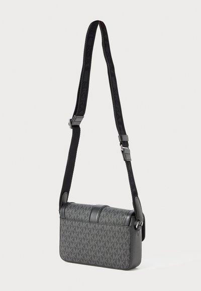 Sac bandoulière gris avec tissu à motif, accents en cuir noir, forme rectangulaire plate et bandoulière ajustable affichant un logo.